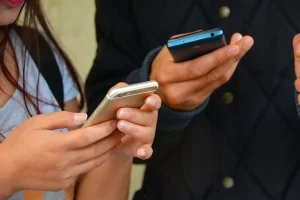 Deux personnes lisant des messages sur leur smartphone